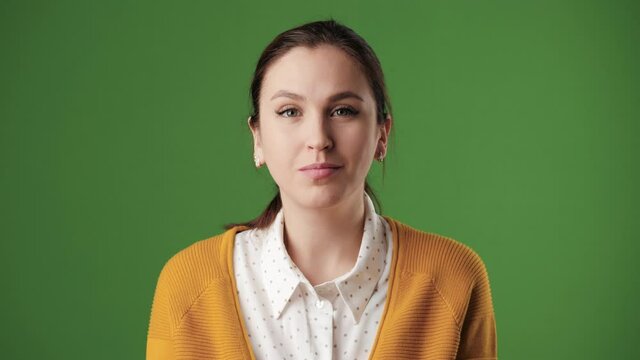 Woman nods in agreement. Positive woman on chroma key background looking at camera and nods her head positively, signaling YES. Slow motion