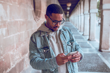 black boy walking using mobile © Jaime