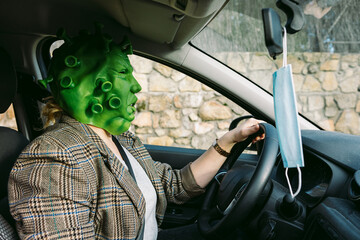 Woman wearing costume - covid-19 coronavirus mask driving a car