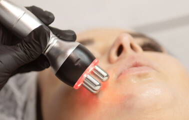 Hardware cosmetology. Closeup picture of happy young woman getting rf lifting procedure in a beauty...