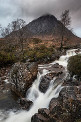 Epic landscape image of Buachaille Etive Mor waterfall in Scottish highlands on a Winter morning with long exposure for smooth flowing water © veneratio