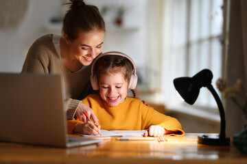 Happy mother supporting daughter during online studies