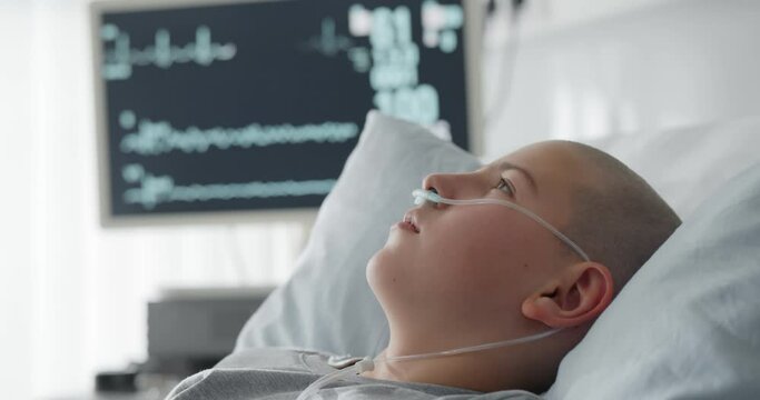 Sick child with cancer lying in hospital bed with nasal cannula