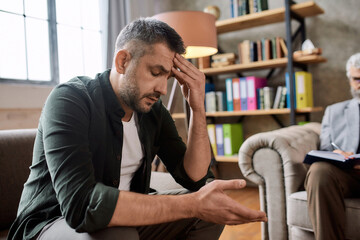 Depressed man during appointment with psychotherapist in office