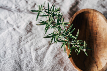rosemary in wooden bowl on towel