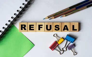 REFUSAL - word on wooden cubes with stationery clips, pencils, notebook
