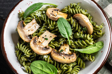 vegetarian dish green penne pasta with spinach and mushrooms. Healthy vegan food. Food recipe background. Close up
