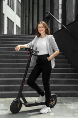 Young woman riding electric scooter in urban background
