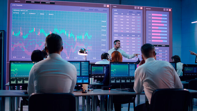 Boss speaking with stock traders in office