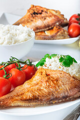 Sea bass grill with rice, greenery and cherry tomatoes. White background.