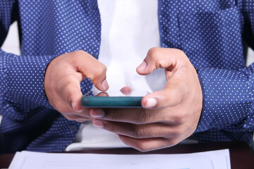 Close up of young man hand using smart phone.