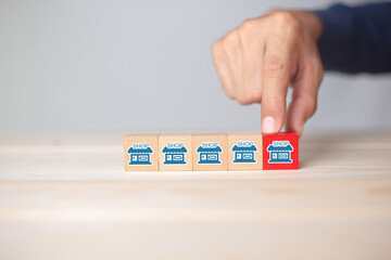 Franchise business,Businessman hand choose wooden blog with franchise marketing icons Store....
