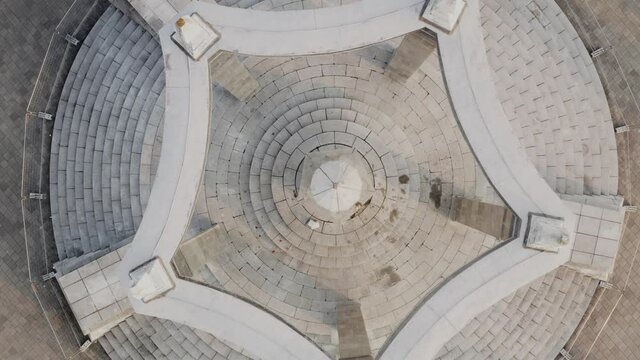 Flying above a mysterious stone altar. Memorial place, forgotten cemetery from above. Top down view of a symmetrical architecturee.
