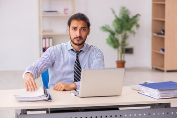 Naklejka premium Young male employee working in the office