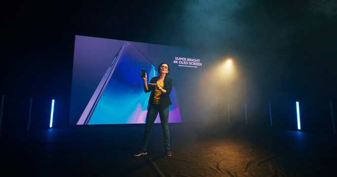 Energetic woman starting smartphone presentation on stage
