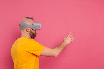 Handsome casual wear men in vr glasses side view pointing to the left text space