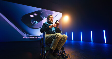Mature speaker with disability showing new cellphone on stage