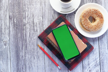 top view of smart phone and notepad on table 