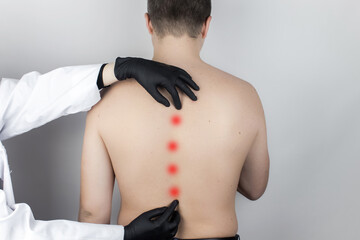 A man at the doctor's appointment with back pain. Treatment of spinal deformity and stoop....