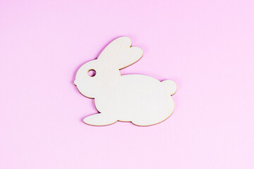 Funny wooden Easter Bunny on light pink background.