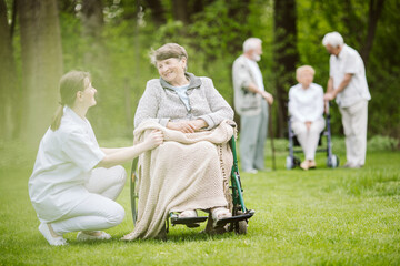 Taking care of the elder disabled woman in the garden