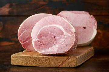 Butcher cutting with knife Cooked festive ham for dinner table and sandwiches