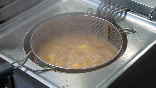 Potatoes being fried on a deep fryer