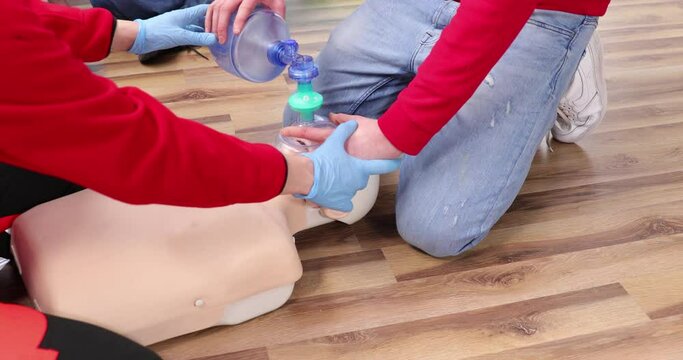 Young people try resuscitation techniques on a dummy. First aid resuscitation, CPR training, medicine, healthcare and medical concept