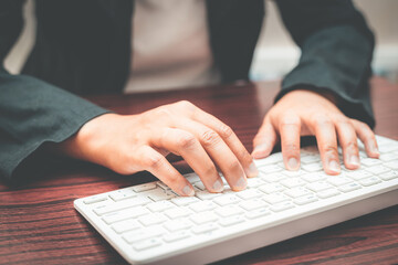 close-up of business woman hand typing and using laptop keyboard for searching with technology networking on working and job on desk at work place or work at home.