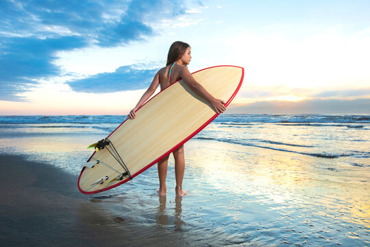 Garota Surfista no amanhecer.
