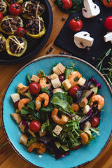 Fototapeta na wymiar Fresh salad plate with shrimp, tomato and mixed greens (arugula, mesclun, mache