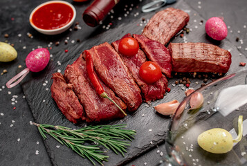 Easter bunny from beef with different roasting of meat , wine bottle and glasses on a stone background with copy space for your text. Easter celebration concept