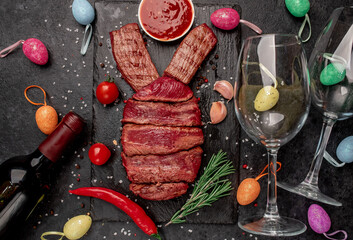 Easter bunny from beef with different roasting of meat , wine bottle and glasses on a stone...