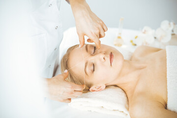 Obraz na płótnie Canvas Beautiful caucasian woman getting face depilation procedure. Beauty and Spa salon concept