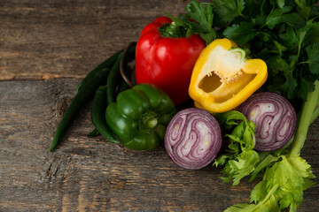 Fresh organic vegetables and herbs on a rustic wooden background