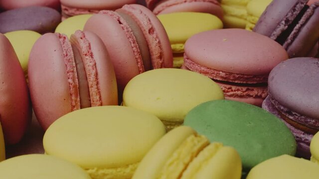 Many colorful cookies. Yellow, pink, green and violet pastries. Delicious french macarons. 