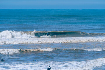 Fototapeta na wymiar Oceano azul, lindo dia de sol para surfar. Pegando onda.