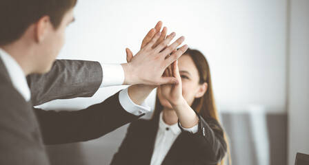 Unknown business people group joining hands in modern office. Businessmen and women making circle with their hands as a team, close-up