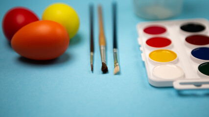 Flat lay set of decorated hand painted chaotically scattered colorful eggs on blue background....