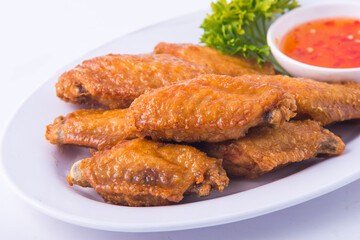 Baked chicken wings and sweet sauce on white background.