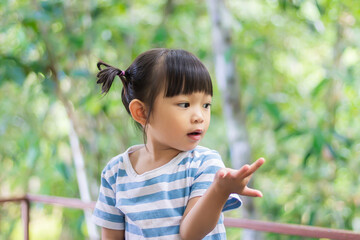 Face​ of​ Asian​ child​ girl​ think​ing​ or​ relaxing, boring.​ Portrait​ image​ of​ 2-3​ years​ old​ kid.​ Emotion, moody​ and​ feeling.​ She​ looking​ at​ something.
