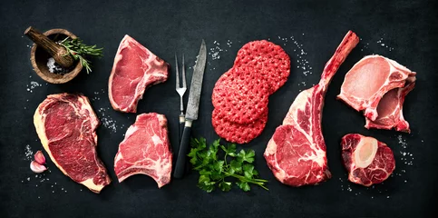 Fotobehang Variety of raw cuts of meat, dry aged beef steaks and hamburger patties © Alexander Raths