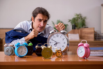 Young male employee sleeping in the office in time management co