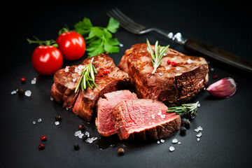 Fototapeta na wymiar Grilled beef filet steaks with herbs and spices on dark slate