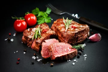 Tuinposter Grilled beef filet steaks with herbs and spices on dark slate © Alexander Raths