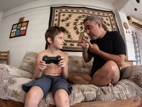 Ni&ntilde;o juega a consola de juegos el padre paga con tarjeta de cr&eacute;dito