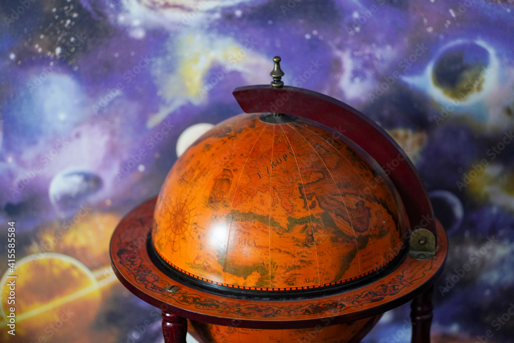 Wall mural an old-fashioned globe on a background of planets