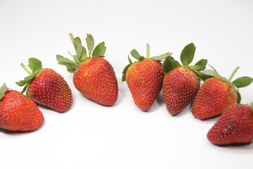 a bunch of creatively arranged strawberries with a white background. selective focus.