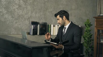 Smiling middle east business man, CEO person working from home, writing a business graph document or a report with computer notebook laptop device in technology concept. - Powered by Adobe