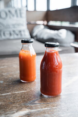 two bottles of chilli sauce and tomato ketchup in the background of the restaurant